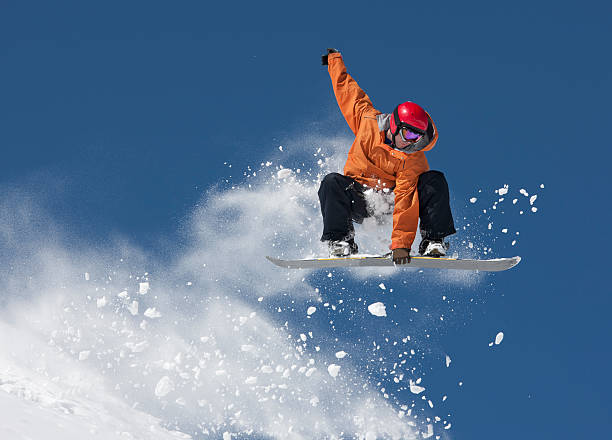 Snowboarder jumping with snow spray